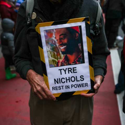 A protestor holds a sign with a photo of Tyre Nichols