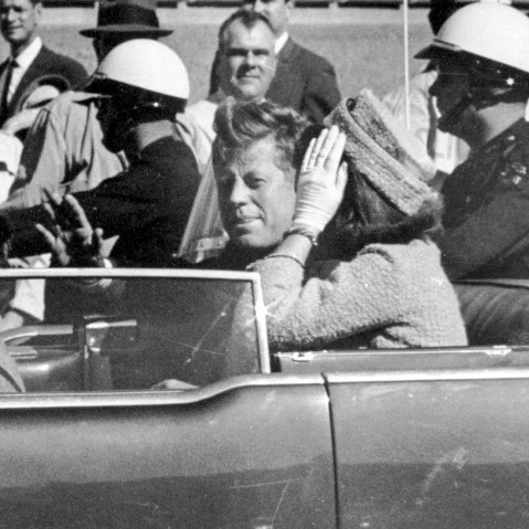 Former President John F. Kennedy waves from his car in a motorcade approximately one minute before he was shot in Dallas, Texas on Nov. 22, 1963.