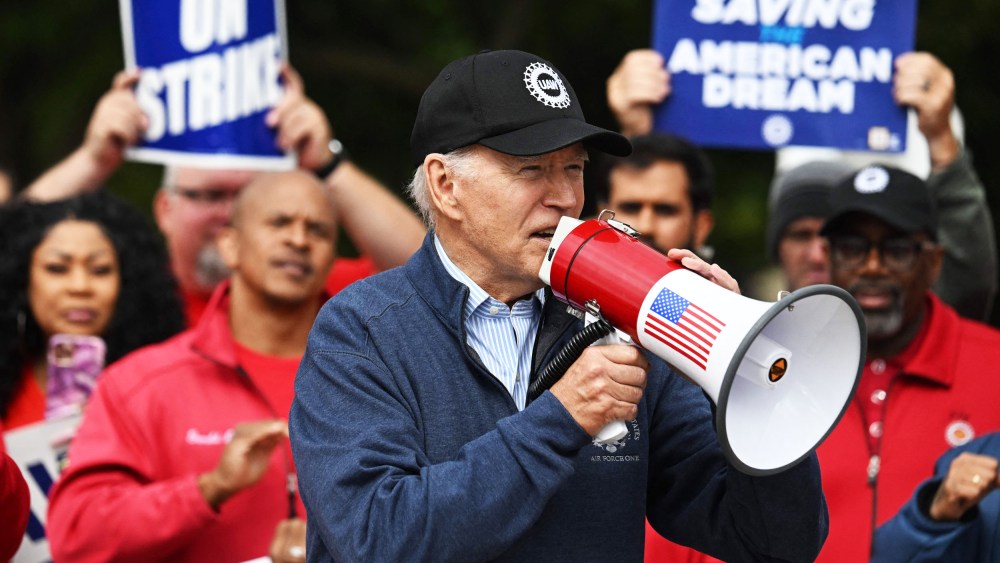 President Joe Biden speaks into a megaphone on a UAW picket line
