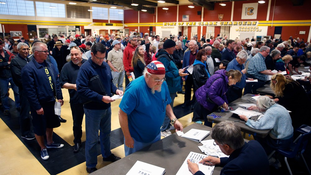 crowds of people line up to get a ballot at a Republican caucus site