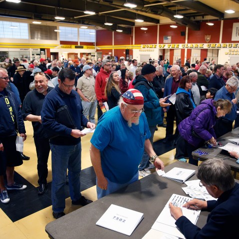 crowds of people line up to get a ballot at a Republican caucus site