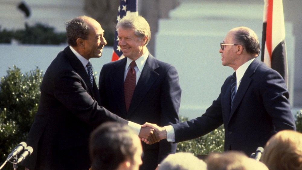 Israeli Prime Minister Menahem Begin, right, and Egyptian President Anwar Sadat, left, shaking hands after signing the Israeli-Egyptian peace treaty under the watch of President Jimmy Carter on the White House lawn on March 26, 1979.