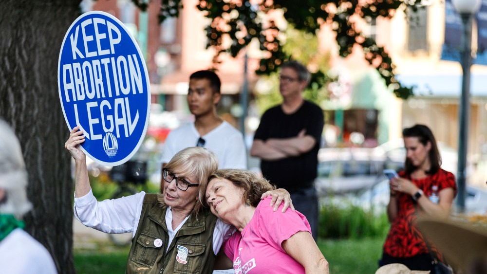 A woman holds a sign saying "Keep Abortion Legal," as demonstrators gather outside the Monroe County Courthouse on July 31, 2023 in Bloomington, Ind.