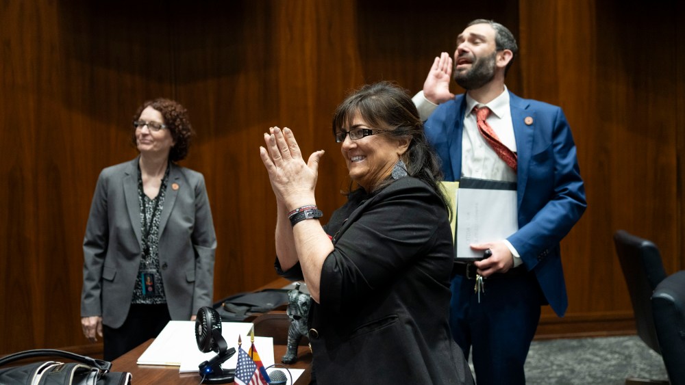 Barbara Parker, center, and Alex Kolodin celebrate their session being called to recess during a legislative session at the Arizona House of Representatives in Phoenix