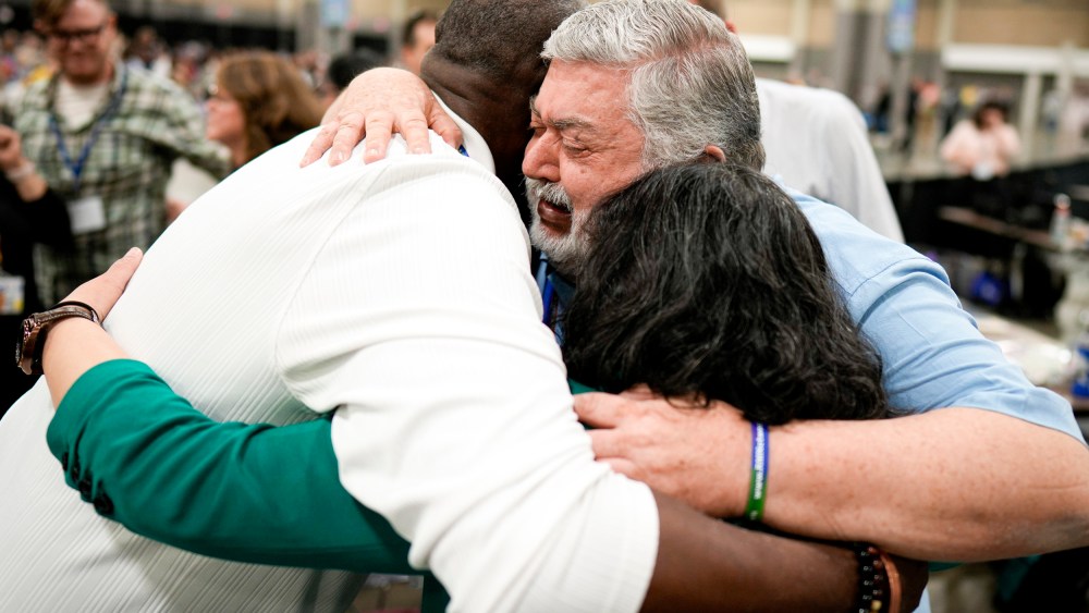 David Meredith, middle, hugs fellow observers.