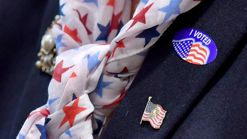A woman wears an "I voted" sticker