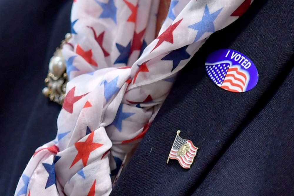 A woman wears an "I voted" sticker