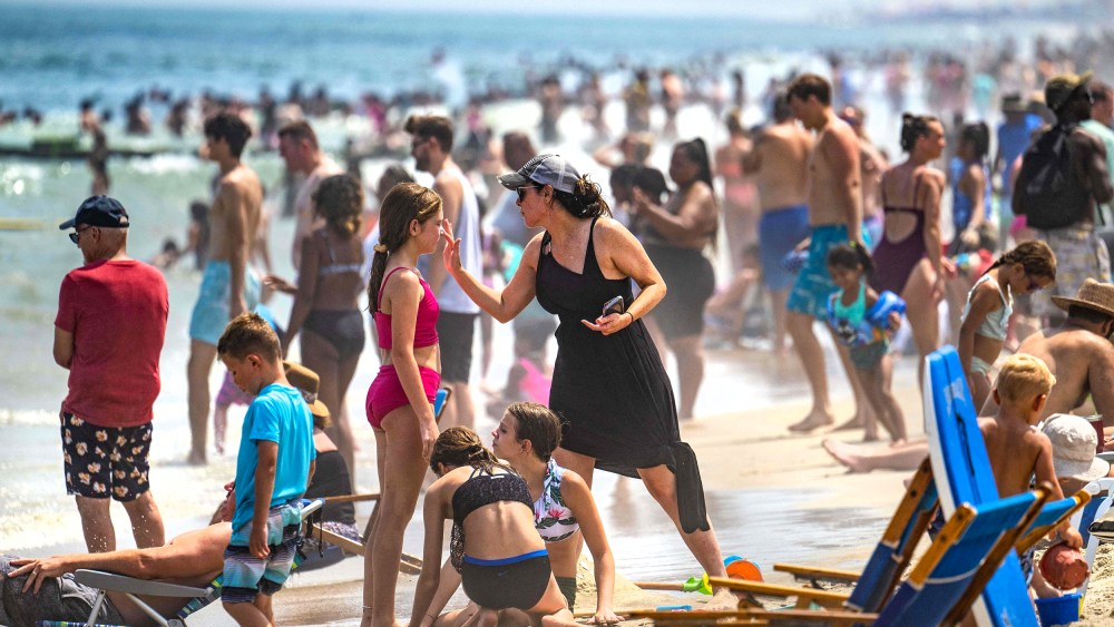 A woman puts sunscreen on a girl's nose