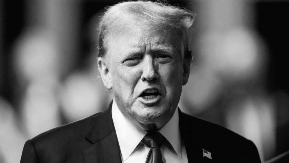 Black and white photo of Donald Trump talking to reporters