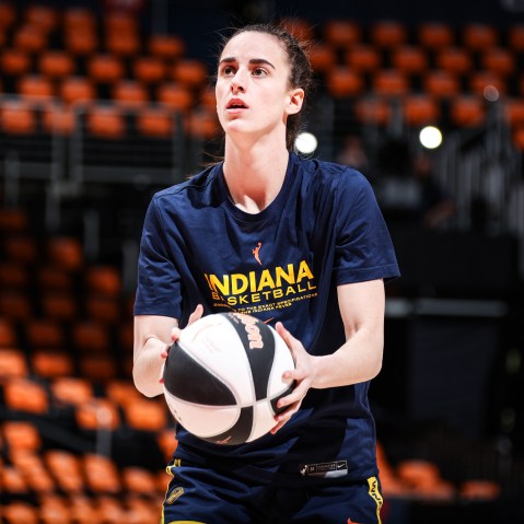 Caitlin Clark holds a basketball on the court
