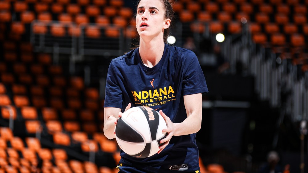 Caitlin Clark holds a basketball on the court