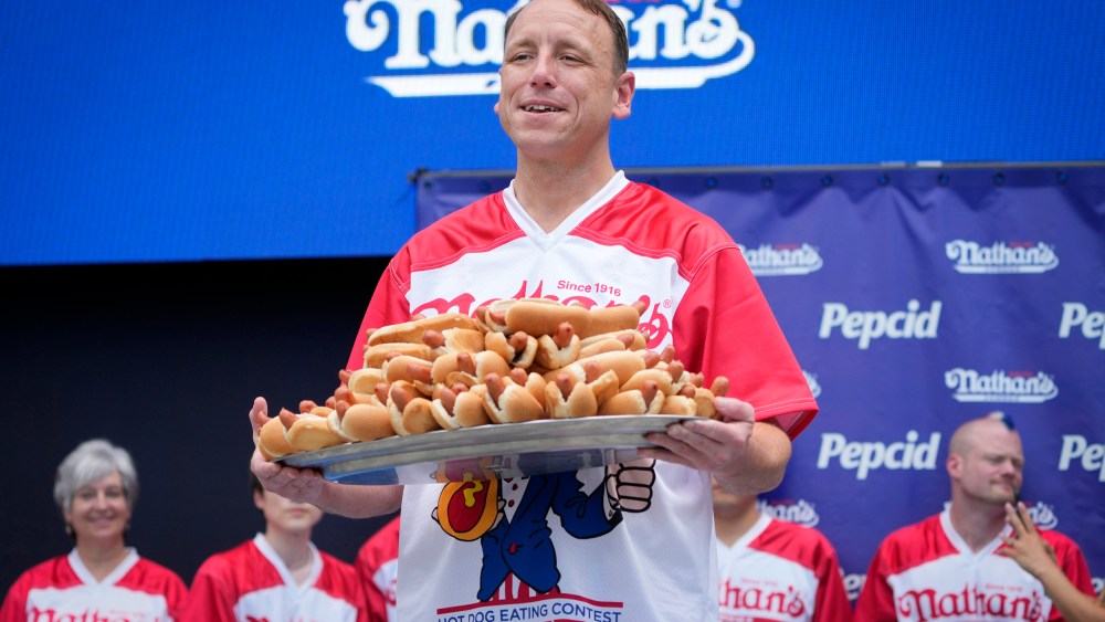 Competitive eater Joey Chestnut holds a plate of hotdogs representing his world record for eating 76 hotdogs and buns in ten minutes during a weigh-in ceremony before the Nathan's Famous July Fourth hot dog eating contest on July 3, 2023, in New York.