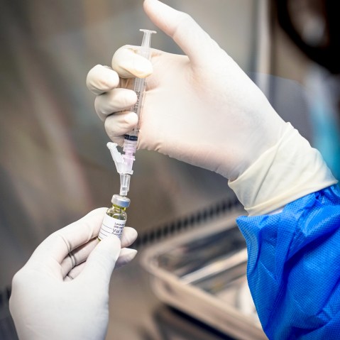 A pharmacist holds a vial of lenacapavir.