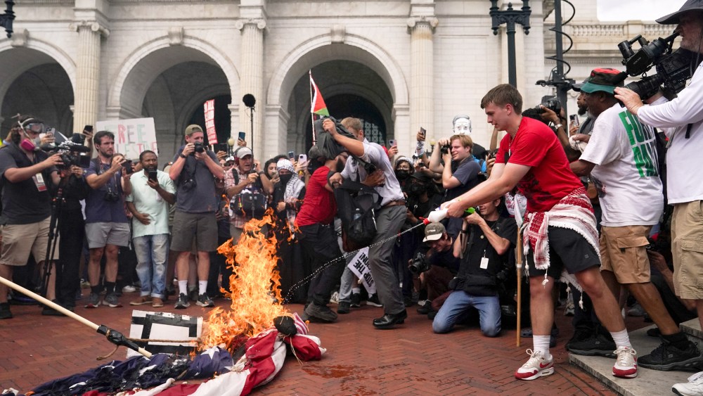 Protesters gather for Israeli PM Netanyahu's address to Congress in Washington US flag burning burners USA