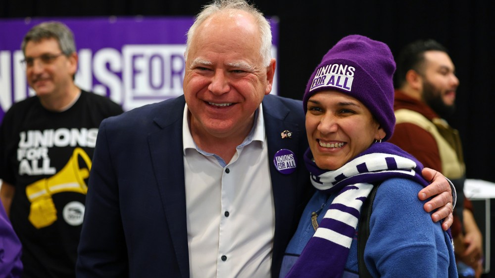 Minnesota Gov. Tim Walz speaks with union organizers before they march on businesses in downtown Minneapolis on Oct. 14, 2022.