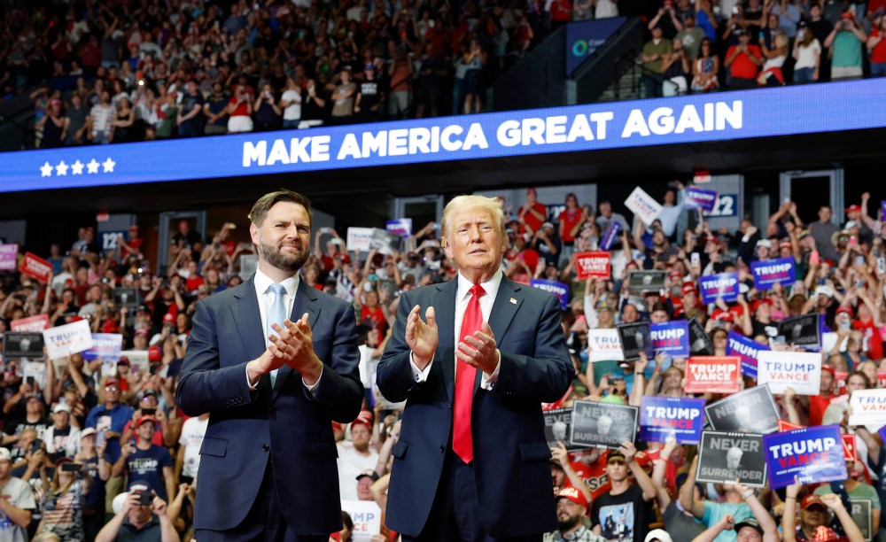 J.D. Vance and Donald Trump stand onstage during a campaign rally at the Van Andel Arena in Grand Rapids, Mich.,