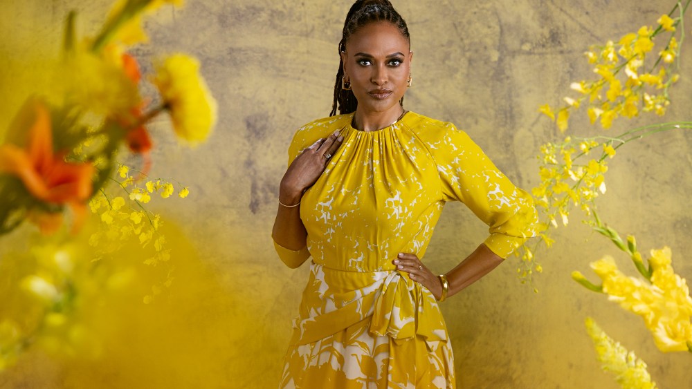Ava DuVernay poses for a photograph among yellow flowers on a set