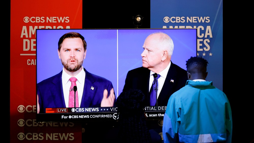 JD Vance And Tim Walz on TV screens.