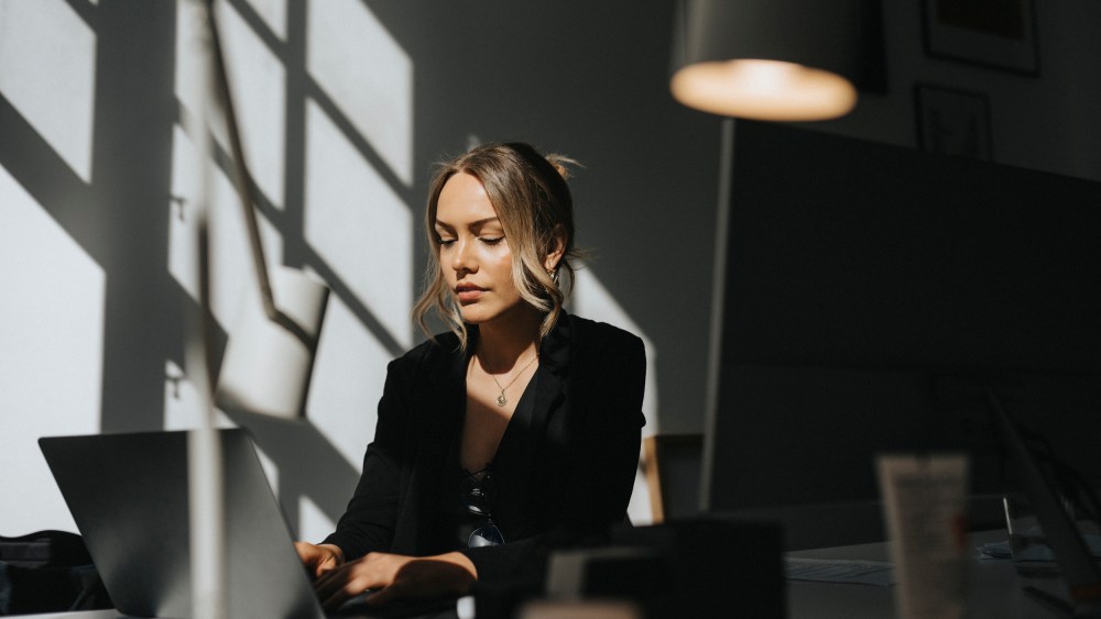 Young businesswoman working on laptop sitting at office
