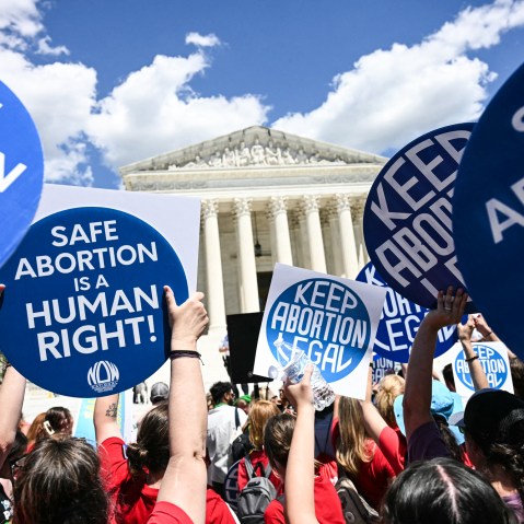 People hold signs saying "Safe Abortion is a Human Right" and "Keep abortion legal"
