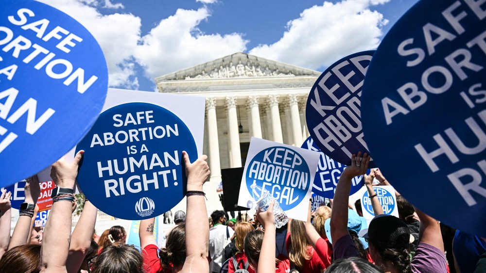 People hold signs saying "Safe Abortion is a Human Right" and "Keep abortion legal"