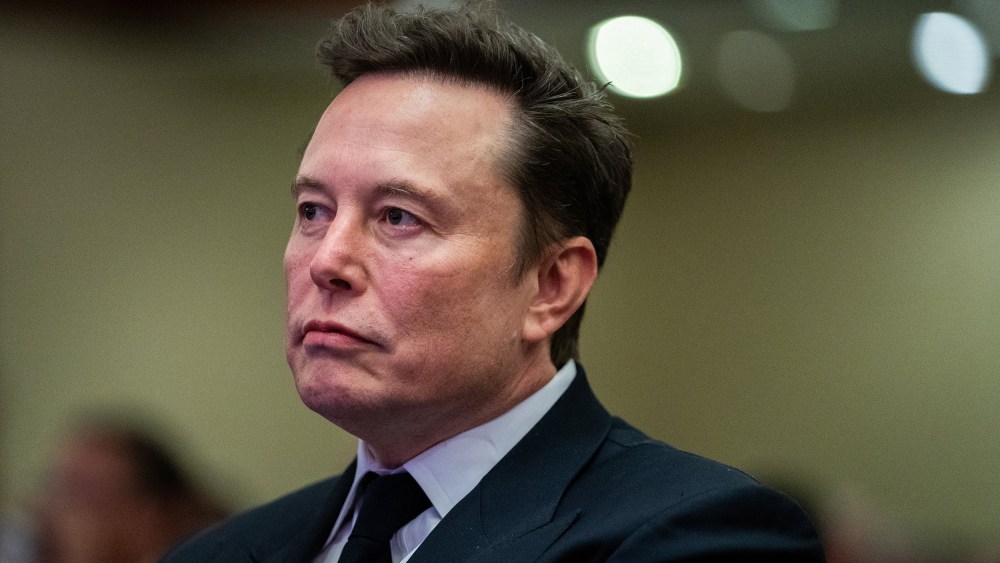 Elon Musk listens as President-elect Donald Trump speaks