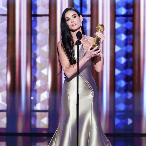Demi Moore holds an award on stage