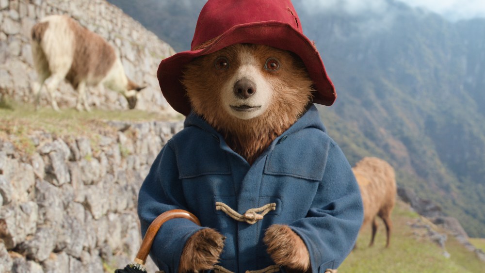A 3D-animated bear wearing a blue peacoat and red hat outside
