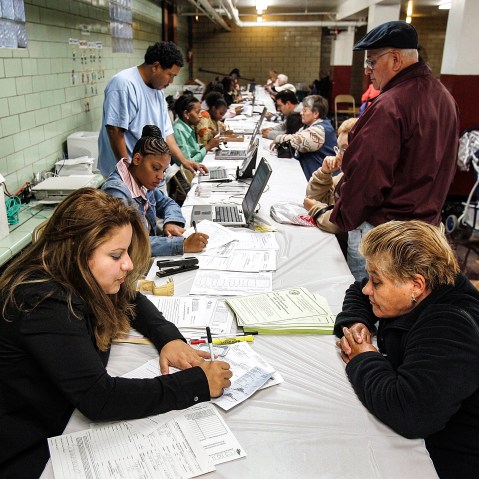 A Chicago Housing Authority counselor helps a Chicago resident with paperwork for the Low Income Home Energy Assistance Program