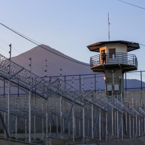 A prison officer stands guard.