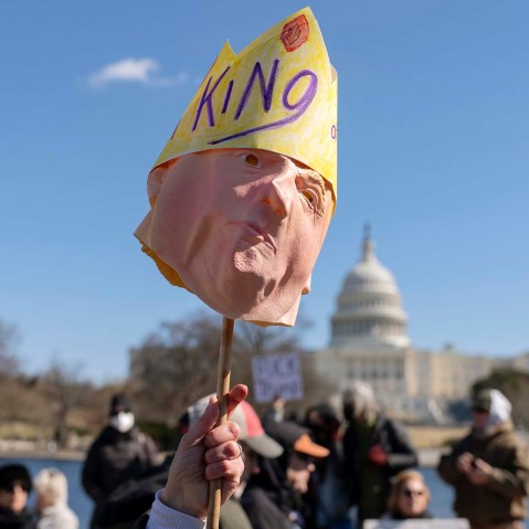 A protester holds up a Trump mask at the Presidents Day "No Kings" protest on Feb. 17, 2025, in Washington.