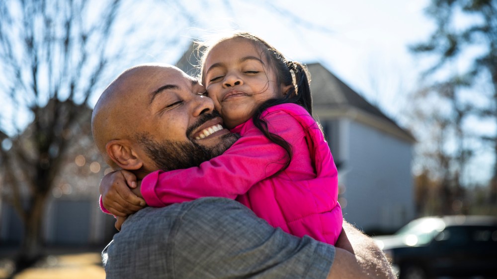 Father holding young daughter outdoors