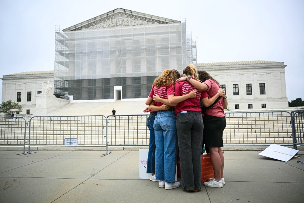 Image: A group of women pray outside the Supreme Court