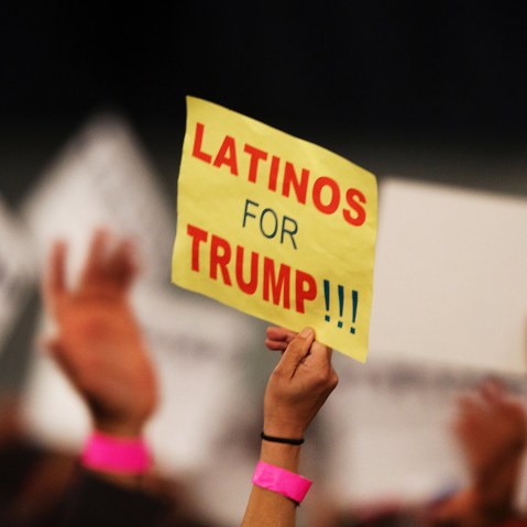 A supporter holds a sign that reads " Latinos for Trump"