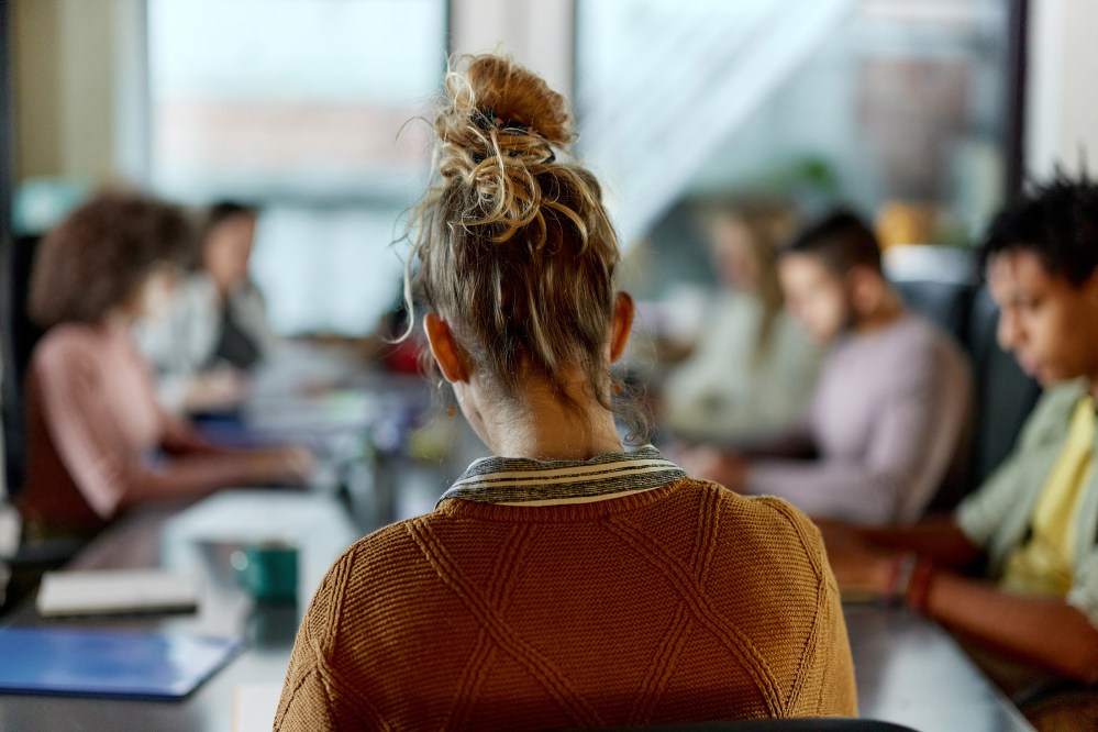 Back view of creative woman on a meeting in the office.