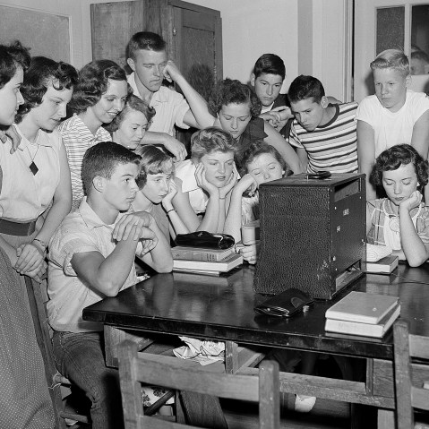 A group of students at the Russell High School in Atlanta, Ga., gather around a radio shortly after noon to hear news that segregation has been ruled out in public schools in a unanimous Supreme Court decision on May 17, 1954.  (Photo by Horace Cort/AP)