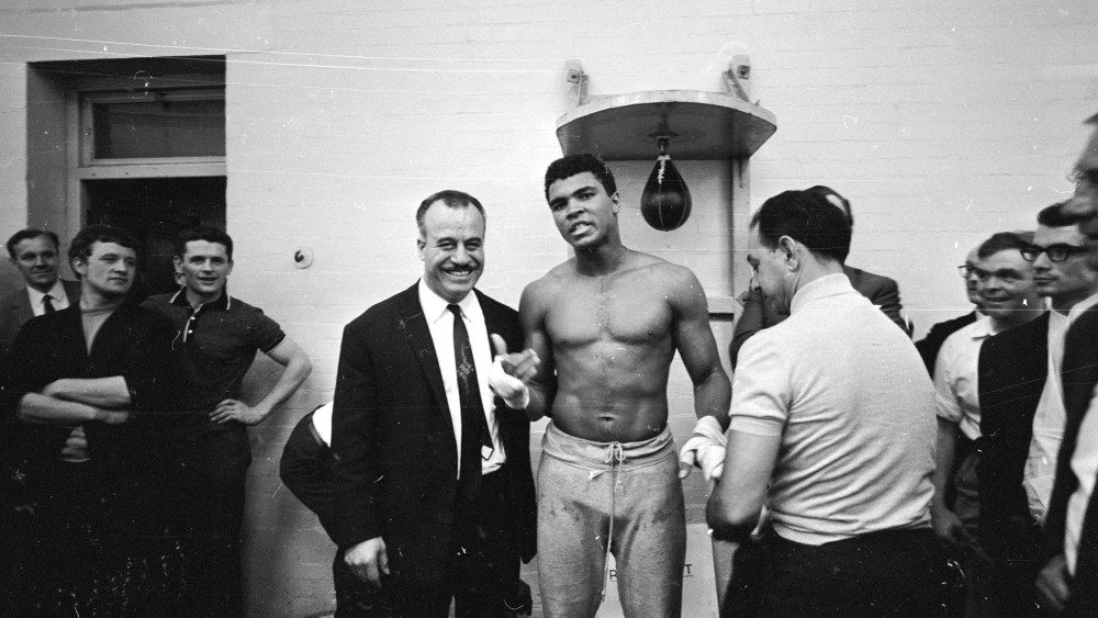 World heavyweight boxing champion Muhammad Ali has his hands bandaged by his manager Angelo Dundee before the day's training session at the Territorial Army Gymnasium at White City, London on May 16, 1966. (R. McPhedran/Express/Getty)