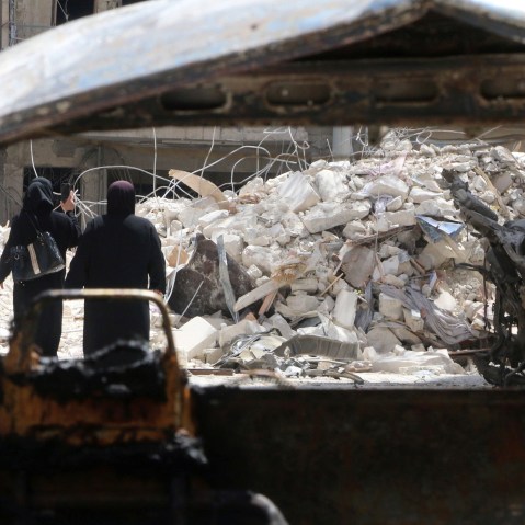 Women walk past damage near al-Quds hospital after it was hit by airstrikes, in a rebel-held area of Syria's Aleppo, April 28, 2016. (Photo by Abdalrhamn Ismail/Reuters)