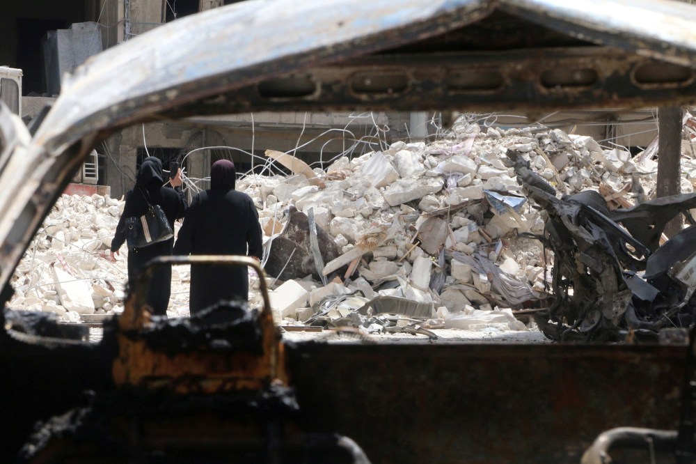 Women walk past damage near al-Quds hospital after it was hit by airstrikes, in a rebel-held area of Syria's Aleppo, April 28, 2016. (Photo by Abdalrhamn Ismail/Reuters)