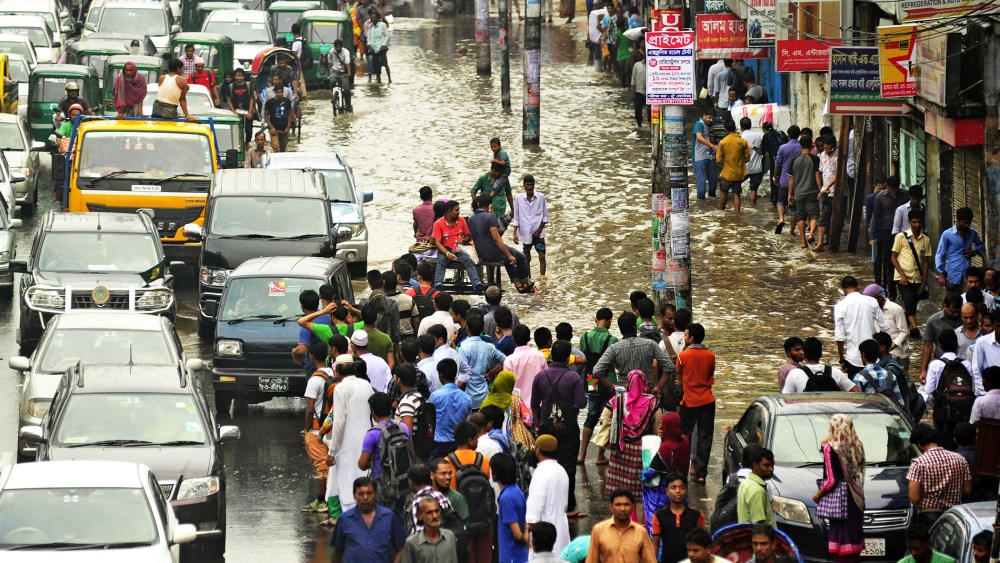 Citizens of Dhaka, Bangladesh are caught in heavy downpour at Kazi Nazrul Islam Avenue on Sept. 1st, 2015. (Photo by Firoz Ahmed/Demotix/Corbis)
