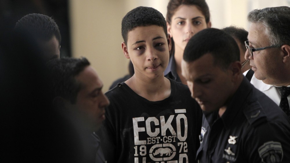 Tariq Abu Khder (C), a Palestinian-US teenager who was allegedly beaten during police custody, arrives for a hearing at Jerusalem Magistrates Court on July 6, 2014.