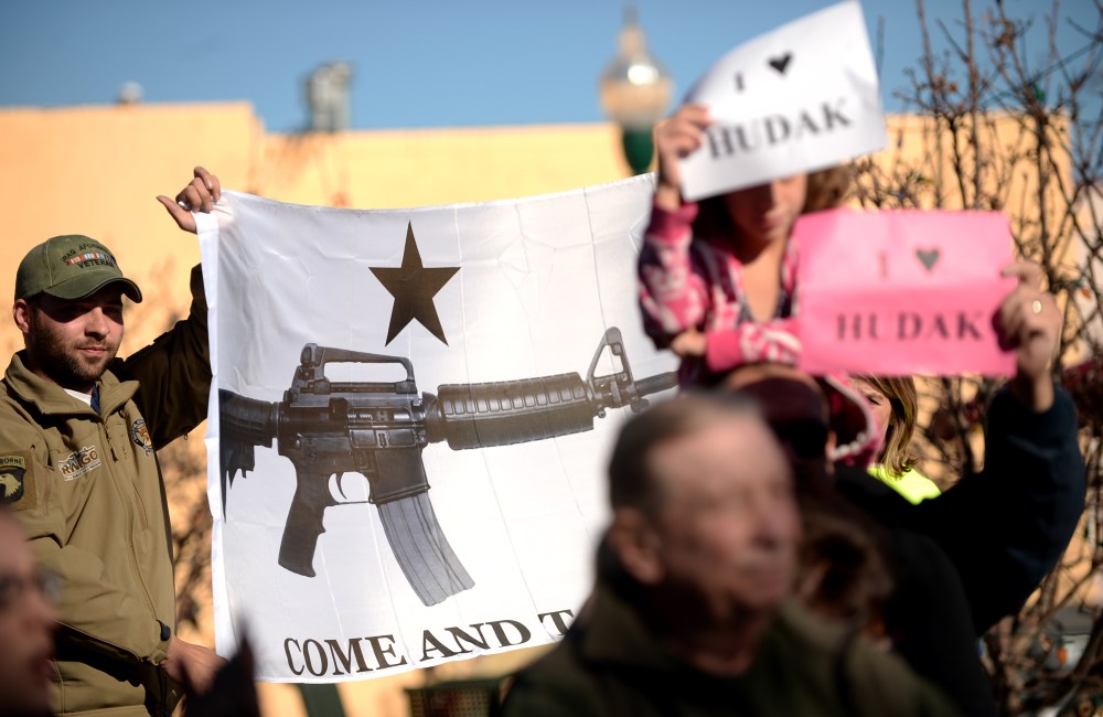Protesters hold the banner by supporters and friends who hold press conference for Democratic state Sen. Evie Hudak at the Arvada Library. Arvada, Colo. on Nov. 27, 2013.