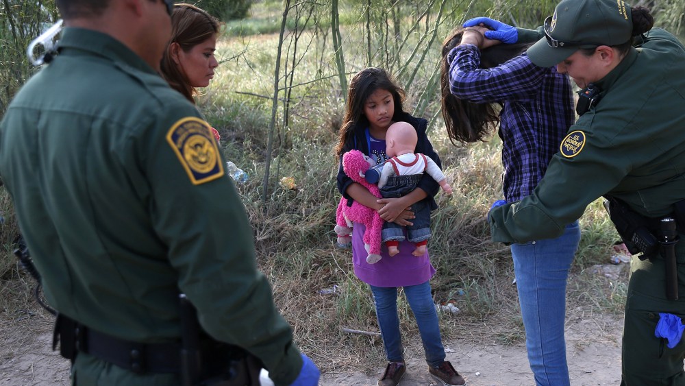 Salvadorian immigrant Stefany Marjorie, 8, watches as a Border Patrol agents body-searches her sister on July 24, 2014 in Mission, Texas.