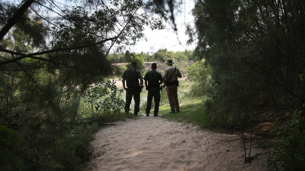 Law enforcement agents watch for immigrants crossing the Rio Grande illegally into the United States on July 24, 2014 in Mission, Texas. (Photo by John Moore/Getty)