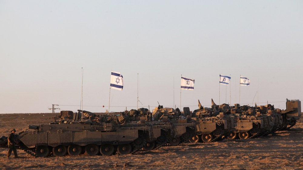 Israeli army's armoured personnel carriers (APC) are positioned along the border between Israel and the Hamas-controlled Gaza Strip on July 26, 2014.