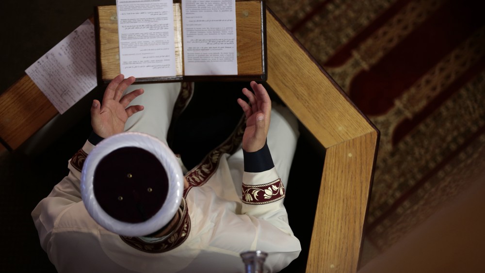 A Muslim religious leader reads Quran as Muslims perform Eid al-Fitr prayer in New York on July 28,2014. (Photo by Bilgin Sasmaz/Anadolu Agency/Getty)
