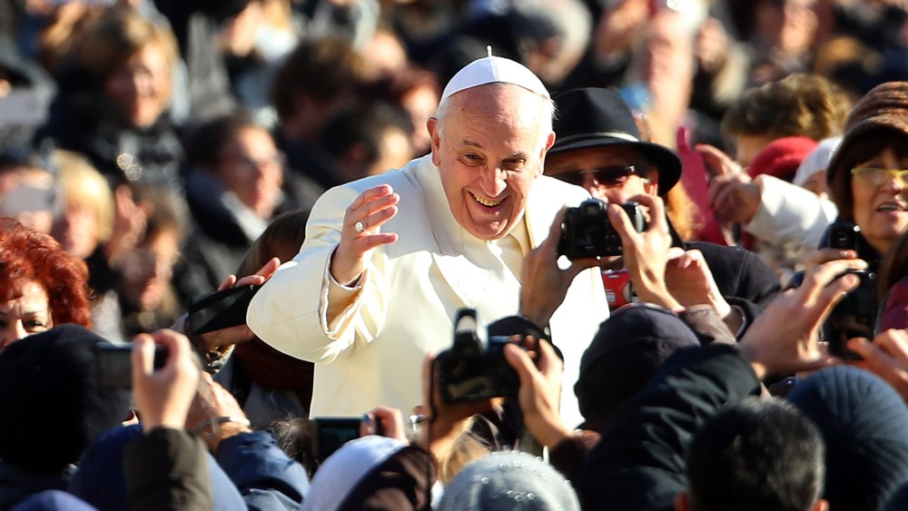 Pope Francis waves to the faithful as he arrives for his weekly audience in Vatican City, Dec. 4, 2013.