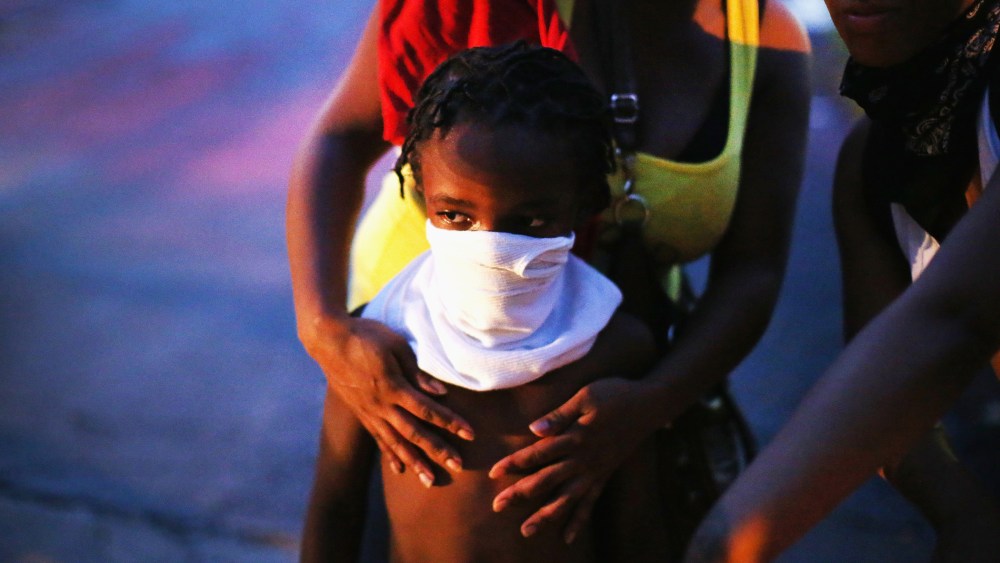A child uses a rag to shield his face from tear gas being fired by police who used it to force protestors from the business district into nearby neighborhoods on Aug. 11, 2014 in Ferguson, Mo.