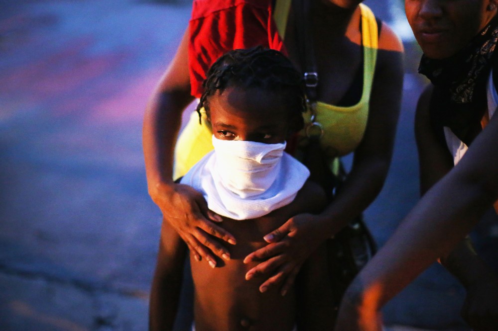 A child uses a rag to shield his face from tear gas being fired by police who used it to force protestors from the business district into nearby neighborhoods on Aug. 11, 2014 in Ferguson, Mo.