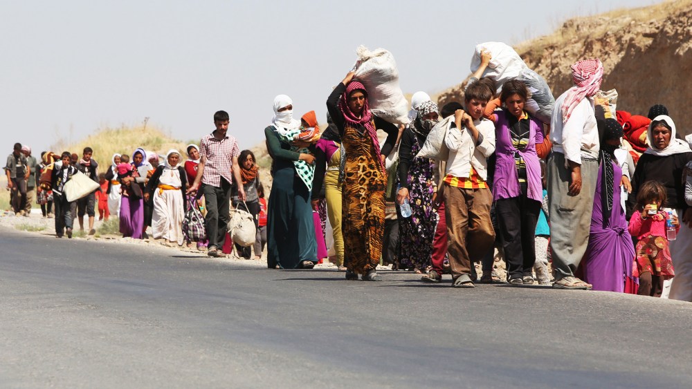 Displaced Iraqi families from the Yazidi community cross the Iraqi-Syrian border at the Fishkhabur crossing, in northern Iraq, on August 13, 2014.